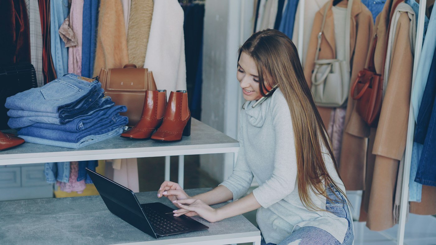 Clothing store owner managing her online shop and marketing on a laptop