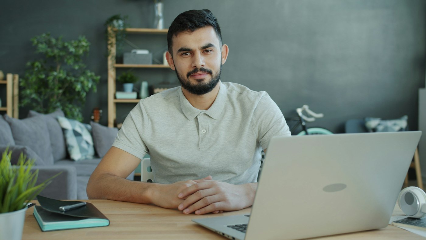 Empresario sentado ante un portátil, listo para hablar de un proyecto de software a medida